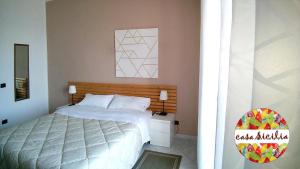 トッレ・ファロにあるCasa Siciliaのベッドルーム1室(ベッド1台付)が備わります。壁には絵画が飾られています。