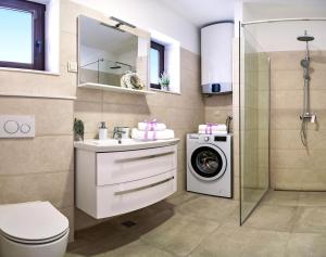a bathroom with a sink and a washing machine at Adria Croatica in Lokva Rogoznica