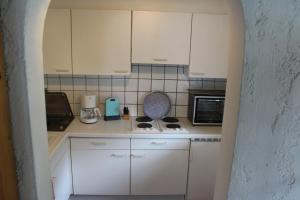 a kitchen with white cabinets and a stove top oven at Appartement-Azalea in Oetz