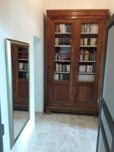 Habitación con espejo y estantería con libros. en LE MOULIN A VENT, en Bertric-Burée