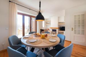 a dining room with a table and blue chairs at Tpa Casa en Pleta de Saga con piscina para 6/8 personas in Ger