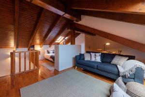 a living room with a blue couch and a bed at Tpa Casa en Pleta de Saga con piscina para 6/8 personas in Ger