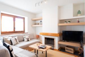 a living room with a couch and a fireplace at Tpa Casa en Pleta de Saga con piscina para 6/8 personas in Ger