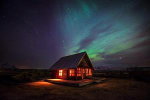 une petite cabine avec les lumières du nord dans le ciel dans l'établissement Hestasport Cottages, à Varmahlid