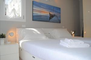 una camera da letto con un letto bianco e un dipinto sul muro di Bnbook - Metropolitan Expo Flat 4 a Rho