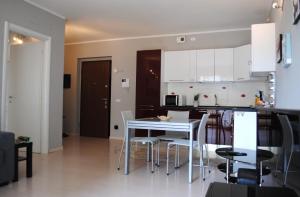 a kitchen with white cabinets and a white table and chairs at Bnbook - Metropolitan Expo Flat 4 in Rho