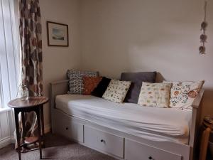 a bed with pillows on it in a room at Rose cottage in Millport