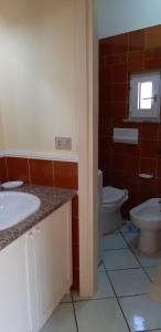 a bathroom with two sinks and a toilet at mare natura confort... il mio paradiso in Sardegna in Isola Rossa
