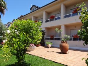 un bâtiment avec des plantes en pot devant lui dans l'établissement Hotel El Pescador, à Perillo