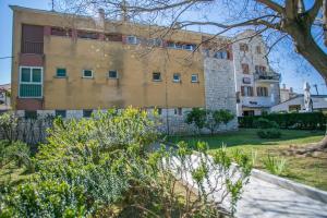 a large building with a tree in front of it at Modern Living in the Heart of Trogir in Trogir