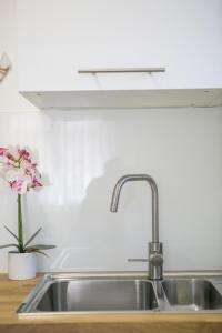 a kitchen sink with a vase of flowers on a counter at Modern Living in the Heart of Trogir in Trogir