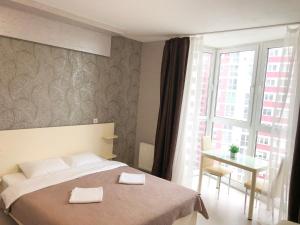 a bedroom with a bed and a table and a window at East Residence in Kyiv