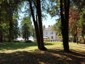 a group of trees in front of a white house at CLOS MARIE in Iguerande