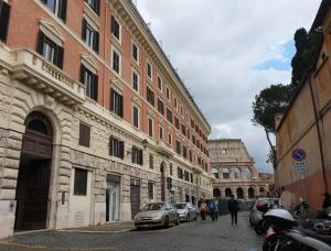 羅馬的住宿－Colosseo Smart Flat，一群人沿着建筑物旁边的街道走着