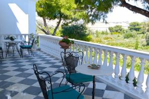 a patio with tables and chairs and a white fence at Priamos Kalitehnoupoli in Rafina