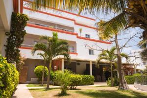 a building with palm trees in front of it at La Résidence in Dakar