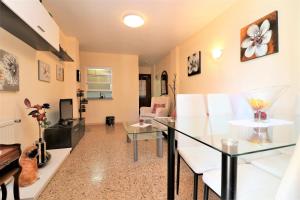 a living room with a glass table and white chairs at Cadiz 4-B in Benidorm