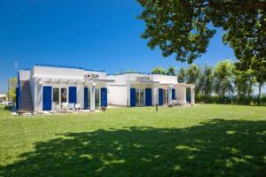 a white house with blue doors and a yard at Conero Infinito in Numana