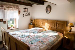 Schlafzimmer mit einem Bett mit einem Kopfteil aus Holz und einem Fenster in der Unterkunft Penzion U Jindry in Železnice