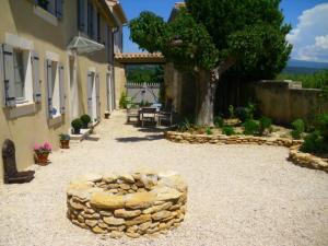 un patio con un círculo de piedra en el centro de un edificio en La Dentellière, en Saint-Hippolyte-le-Graveyron