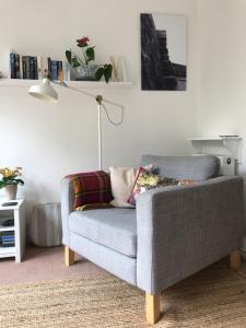 a grey couch in a living room with a lamp at Coverdale in Lyme Regis