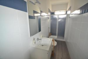 Baño blanco con lavabo y aseo en Case degli Avi, camere nel Borgo marinaro, en Pozzallo