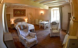 1 dormitorio con 1 cama, 2 sillas y mesa en Château de la Grand'cour en Grandchamp-des-Fontaines