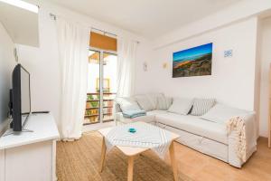 a living room with a couch and a tv at Quinta da Gomeira by Algartur in Cabanas de Tavira
