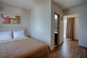 a bedroom with a large bed and a window at Irini Hotel in Heraklio