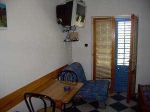 a living room with a table and a chair and a tv at Apartments Jadranka - 200 m from sea in Sućuraj