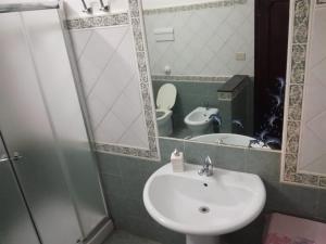 ein Badezimmer mit einem Waschbecken, einem WC und einem Spiegel in der Unterkunft Casa Ciccio in Terrasini