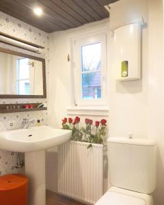 ein Bad mit einem Waschbecken, einem WC und einem Fenster in der Unterkunft Hexenhäuschen Dreieichenhain in Dreieich