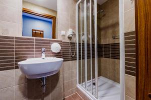a bathroom with a sink and a shower at Hotel Wyspiański in Krakow