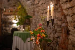 a vase with flowers and candles on a table at Laubgassl in Mörbisch am See