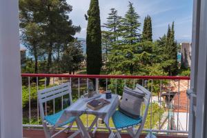 a table and two chairs on a balcony at Seaside Apartments Pinezic in Malinska