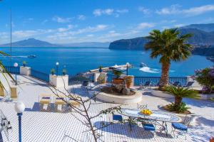 een uitzicht op de oceaan vanuit een resort met tafels en stoelen bij La Terrazza 38 in Sorrento