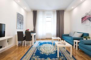 a living room with a blue couch and a table at City Center Apartments in Zagreb