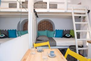 a room with two bunk beds and a table and chairs at Cute Mykonos DownTown Studio in Mýkonos City