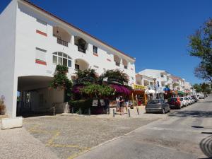 un bâtiment avec des fleurs sur le côté d'une rue dans l'établissement Apartment on The Strip Albufeira, à Albufeira