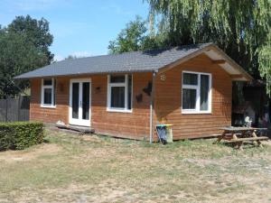 una pequeña casa con una mesa de picnic delante de ella en Hoeveheikant Chalets, en Lage Mierde