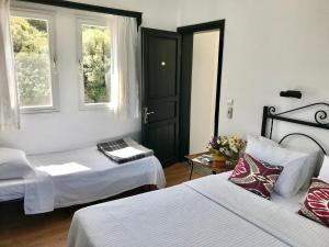 a room with two beds and a door with windows at Hotel Villa Tokur in Datca