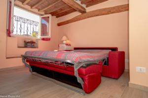 卢卡Casa Anfiteatro的窗户客房内的一张红色的床