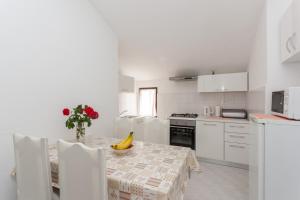 a white kitchen with a table with a banana on it at Villa Anka in Cavtat