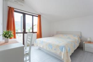 een witte slaapkamer met een bed en een raam bij Villa Anka in Cavtat