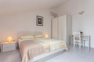 Habitación blanca con cama y escritorio en Villa Anka, en Cavtat