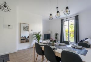 ein Esszimmer und ein Wohnzimmer mit einem Tisch und Stühlen in der Unterkunft Nice Apartment Garden - 5 min DISNEYLAND Paris - Val d'Europe Center in Chessy