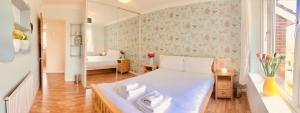 a bedroom with a white bed with flowers on the wall at Apple Perch 2BR Flat - Free Parking in Oxford