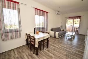 ein Wohnzimmer mit Tisch und Couch in der Unterkunft Apartmani Lukic in Vir
