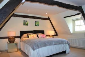 1 dormitorio con 1 cama, 2 lámparas y ventana en 6 St Peter's Hill, en Stamford