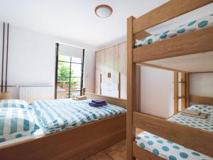 a bedroom with two bunk beds and a window at Apartma Matajurc in Trnovo ob Soči